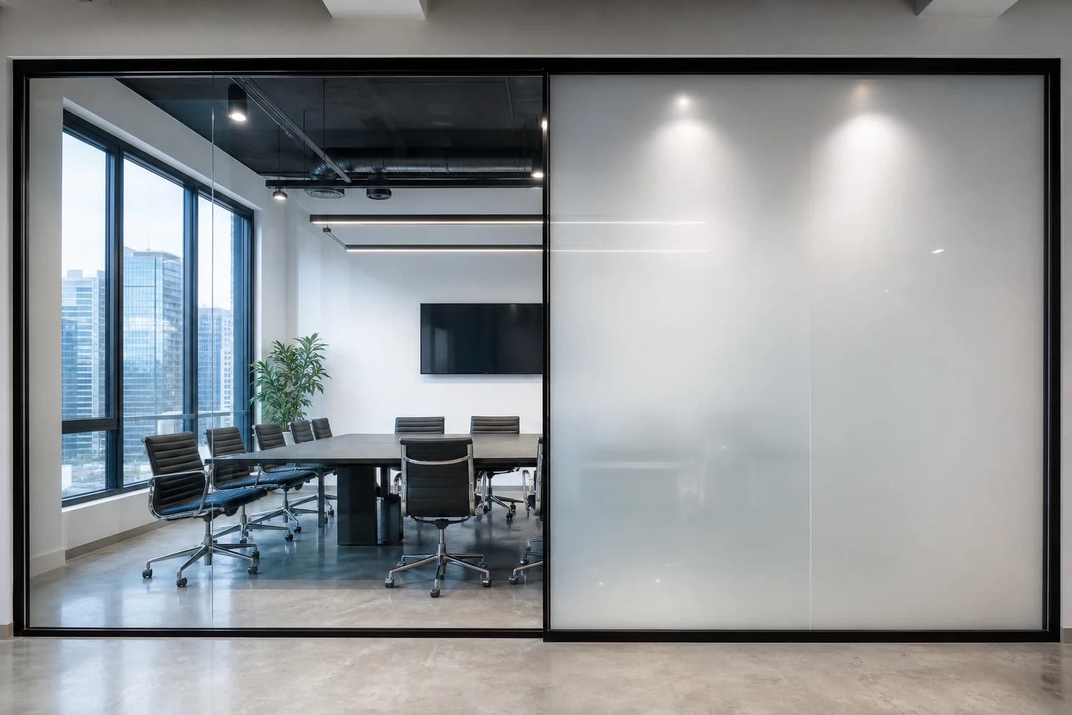 SmartPrivacy glass partition switching from clear to frosted in a modern office